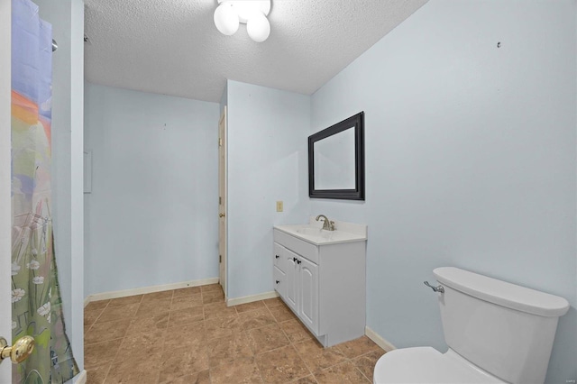 full bathroom with toilet, baseboards, a textured ceiling, and vanity