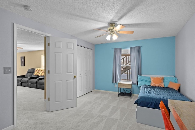 bedroom featuring a textured ceiling, a ceiling fan, baseboards, a closet, and carpet