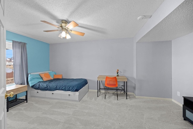 bedroom featuring light carpet, ceiling fan, a textured ceiling, and baseboards