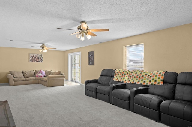 living area with light carpet, ceiling fan, and a textured ceiling