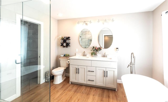 full bathroom featuring wood finished floors, tiled shower, and a sink