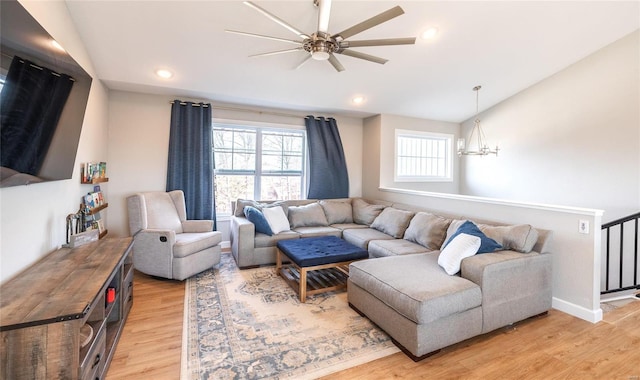 living room with recessed lighting, baseboards, lofted ceiling, light wood-style floors, and ceiling fan with notable chandelier