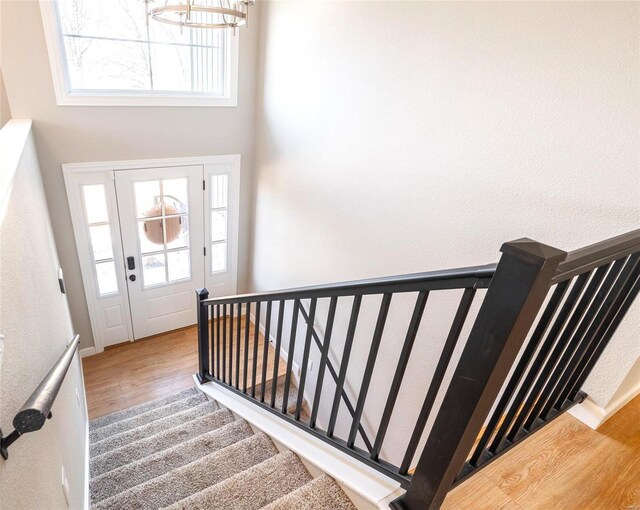 stairs featuring a healthy amount of sunlight and wood finished floors