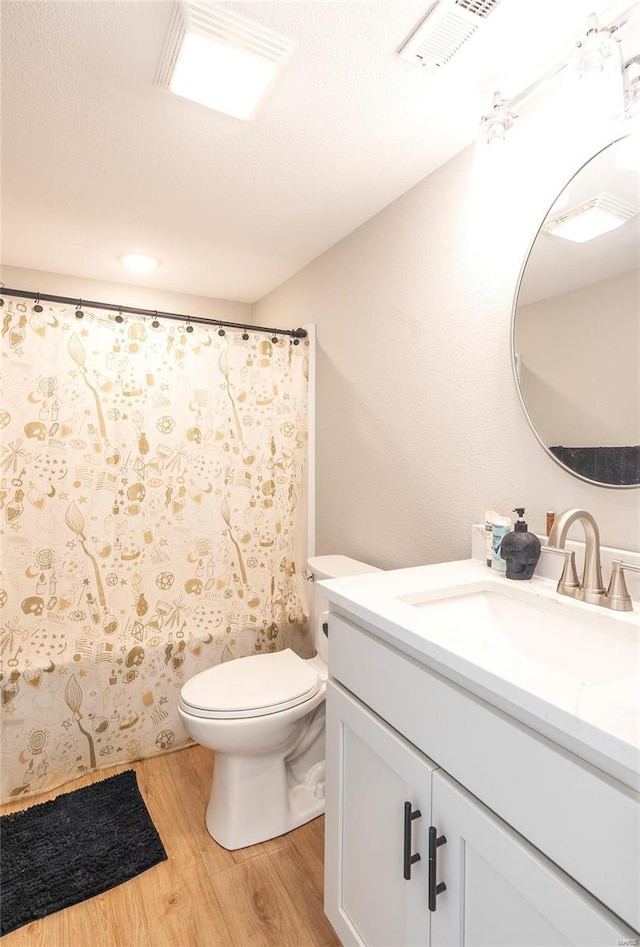 full bathroom with toilet, wood finished floors, vanity, visible vents, and a shower with curtain