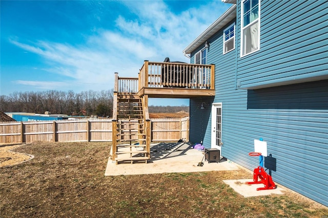 view of yard with a deck, a patio area, fence, and stairs