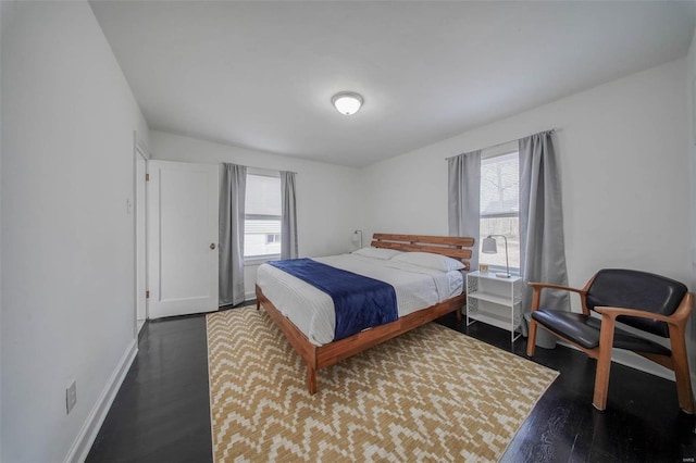 bedroom with dark wood finished floors and baseboards