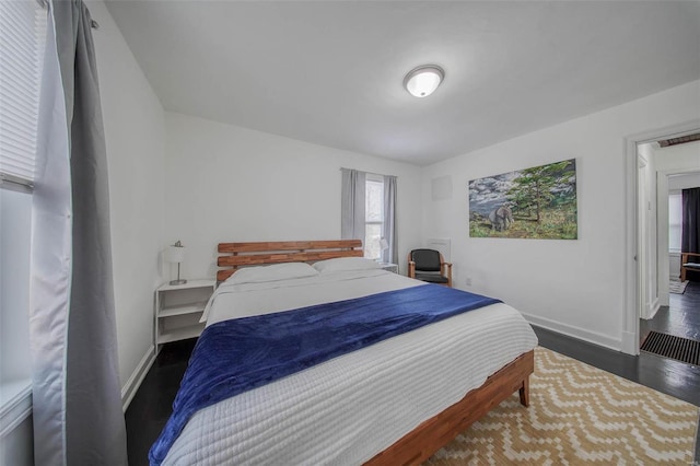 bedroom featuring baseboards and wood finished floors