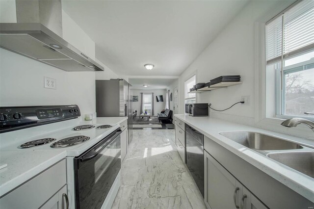 kitchen featuring marble finish floor, light countertops, appliances with stainless steel finishes, a sink, and wall chimney range hood