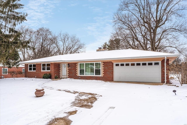 ranch-style home featuring a garage, a chimney, and brick siding