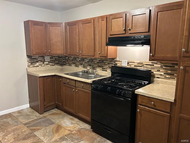 kitchen featuring sink, gas stove, exhaust hood, and backsplash