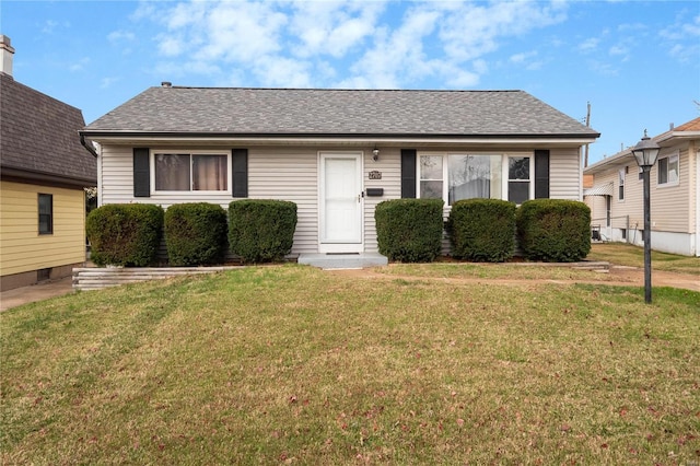 bungalow with roof with shingles and a front yard