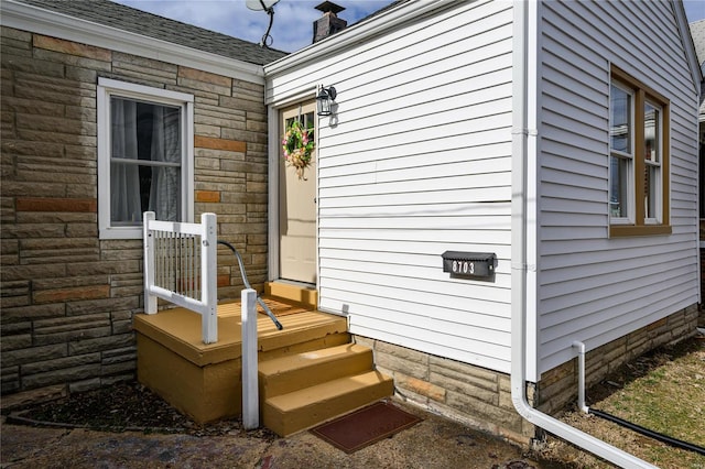 view of property exterior with stone siding and roof with shingles