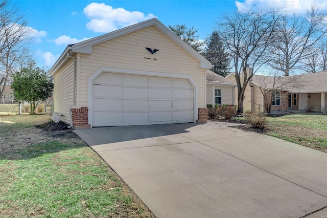 exterior space with a front yard, concrete driveway, and brick siding