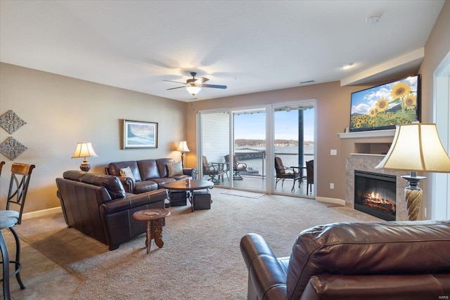 living room featuring carpet, a fireplace with flush hearth, a ceiling fan, and baseboards