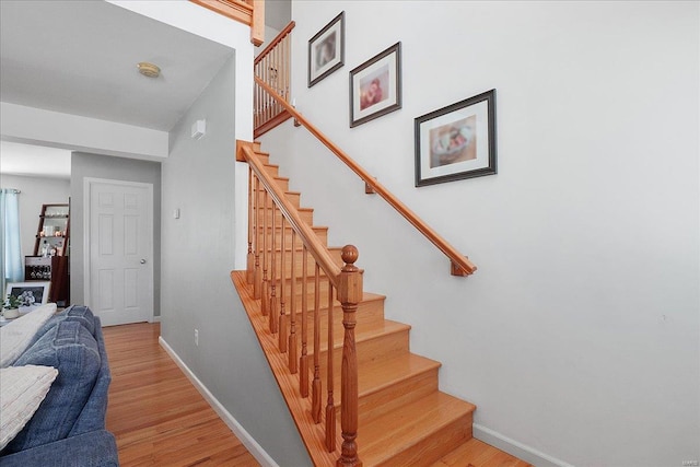 stairway with wood finished floors and baseboards