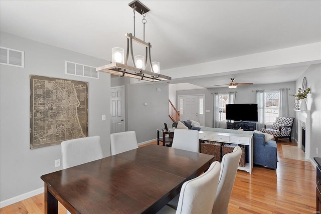 dining area featuring light wood-style floors, baseboards, and visible vents