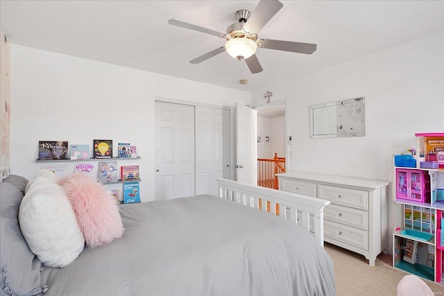 bedroom featuring ceiling fan, a closet, and light colored carpet