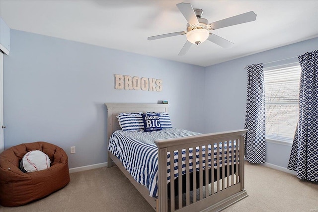 bedroom with light colored carpet, ceiling fan, and baseboards