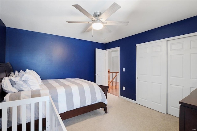 bedroom with a closet, light carpet, and ceiling fan