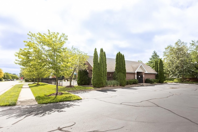 view of front of property with uncovered parking and fence