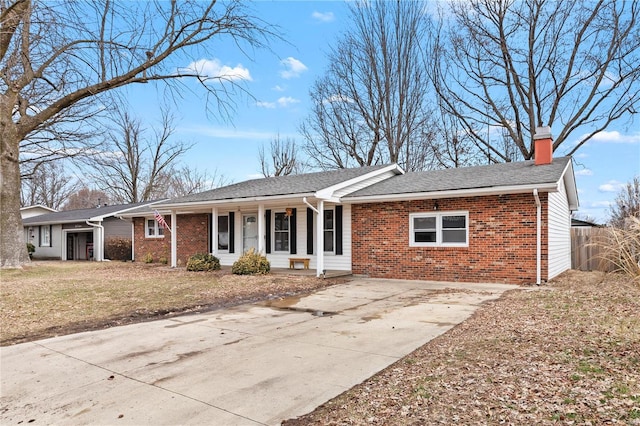 single story home with a porch, brick siding, driveway, a chimney, and a front yard