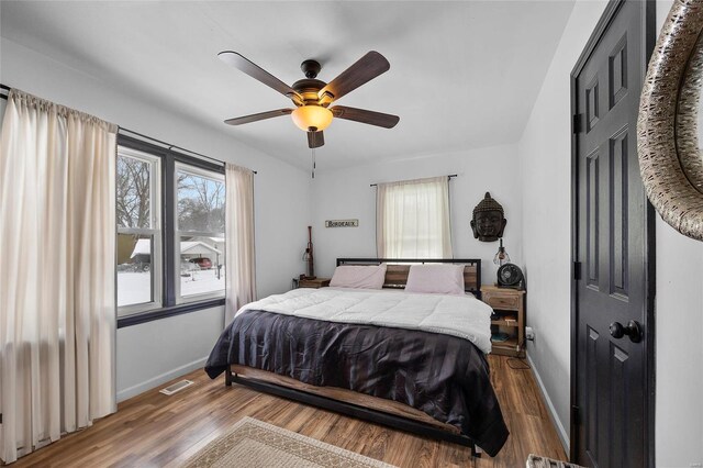 bedroom with multiple windows, visible vents, and wood finished floors