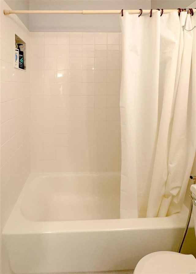 bathroom featuring shower / bath combination with curtain and toilet