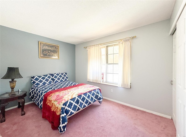 bedroom featuring carpet, baseboards, and a textured ceiling