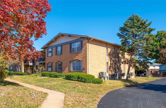 view of property exterior featuring a lawn and brick siding