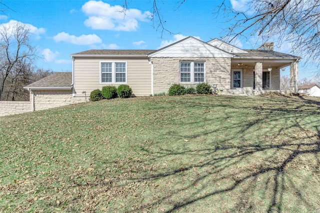 ranch-style house with stone siding, a front lawn, and a chimney