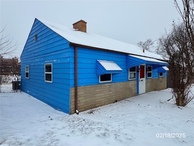 view of snow covered exterior featuring central AC