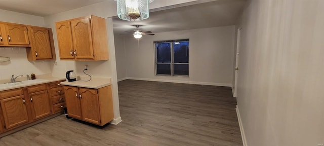 kitchen featuring brown cabinets, light wood-style flooring, light countertops, and a sink