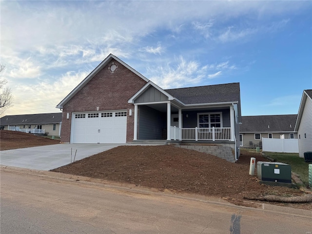 view of front facade with a porch, a garage, brick siding, and driveway