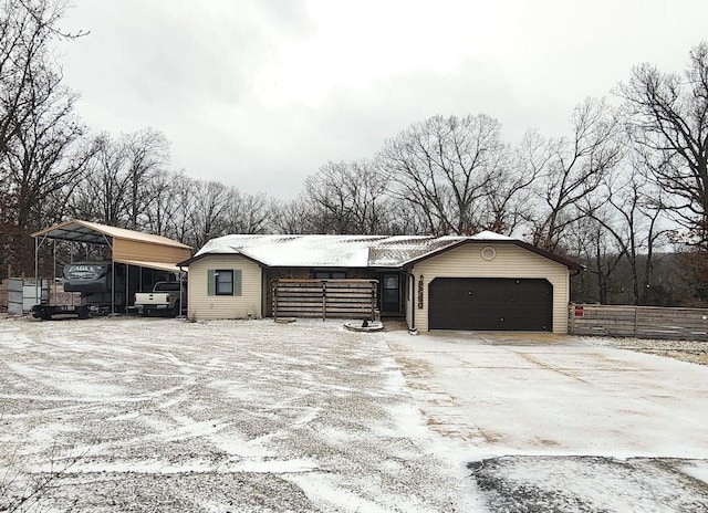 snow covered garage with a carport