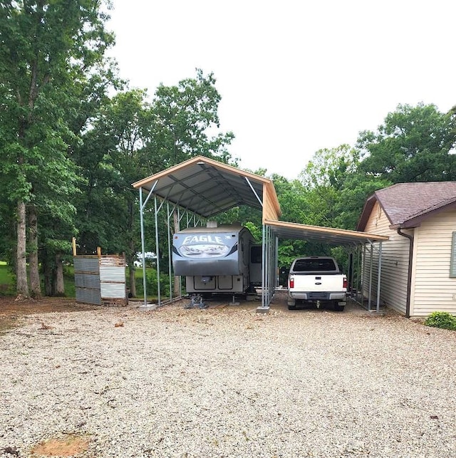 view of parking / parking lot with gravel driveway and a detached carport