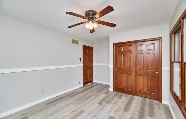 unfurnished bedroom featuring a closet, light wood-type flooring, visible vents, and baseboards