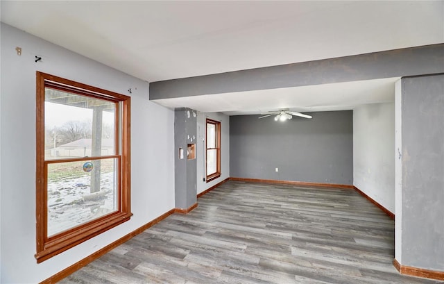 spare room featuring light wood-type flooring, ceiling fan, and baseboards