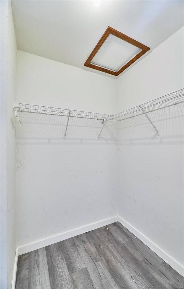 spacious closet featuring attic access and wood finished floors