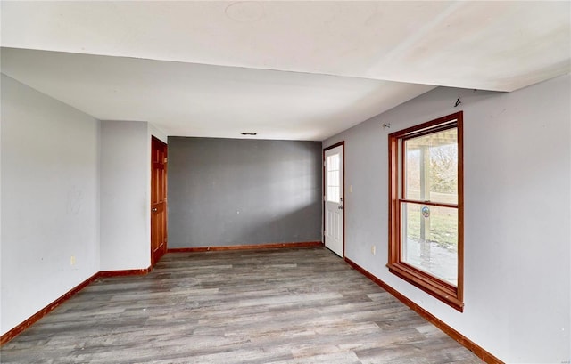 empty room with baseboards and light wood-style floors