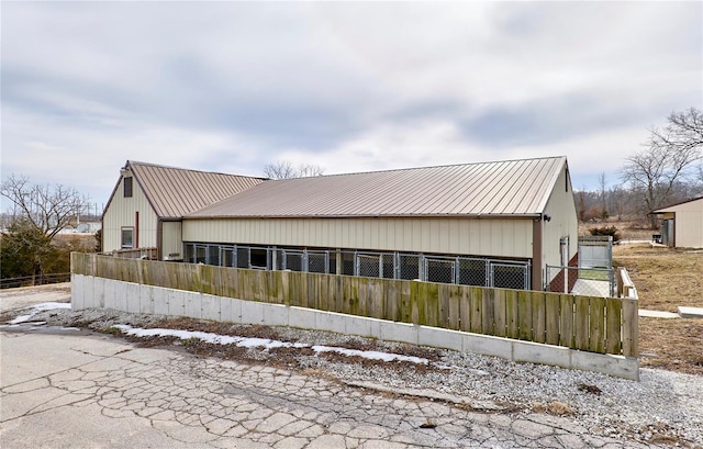 exterior space with a fenced front yard and metal roof