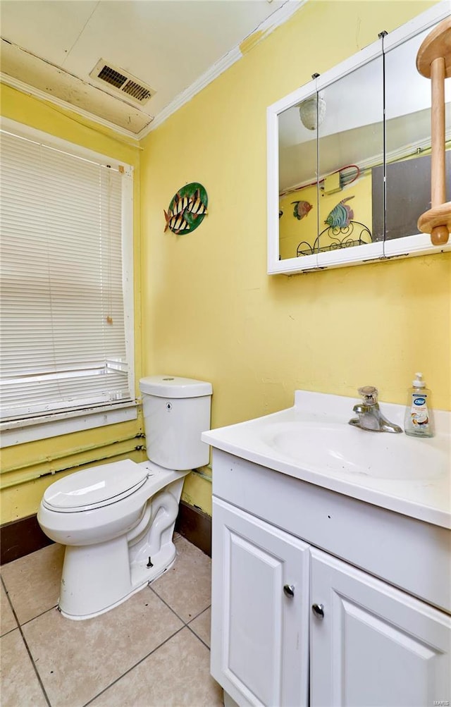 half bathroom featuring toilet, vanity, visible vents, ornamental molding, and tile patterned floors