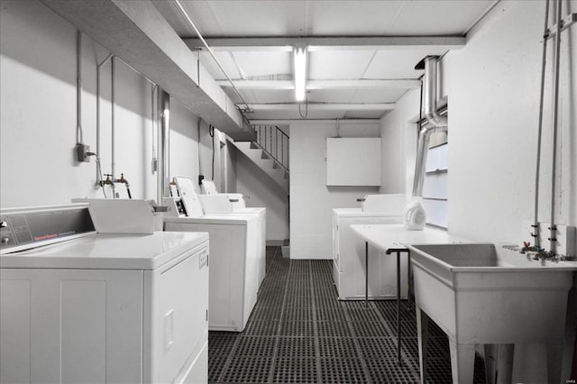 clothes washing area featuring a sink and washer and clothes dryer