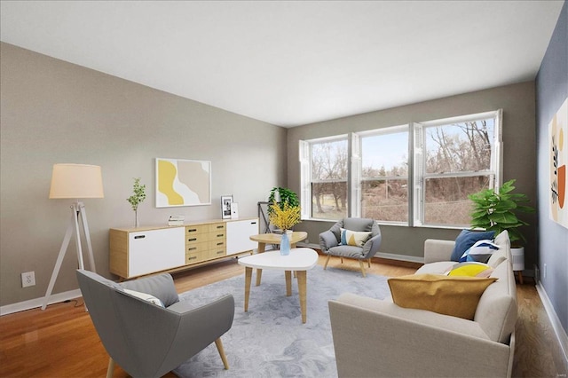 living area featuring light wood finished floors, lofted ceiling, and baseboards