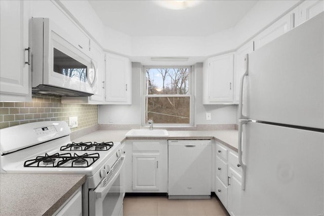 kitchen with white cabinetry, white appliances, light countertops, and a sink