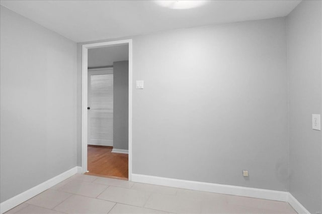 unfurnished room featuring light tile patterned floors and baseboards