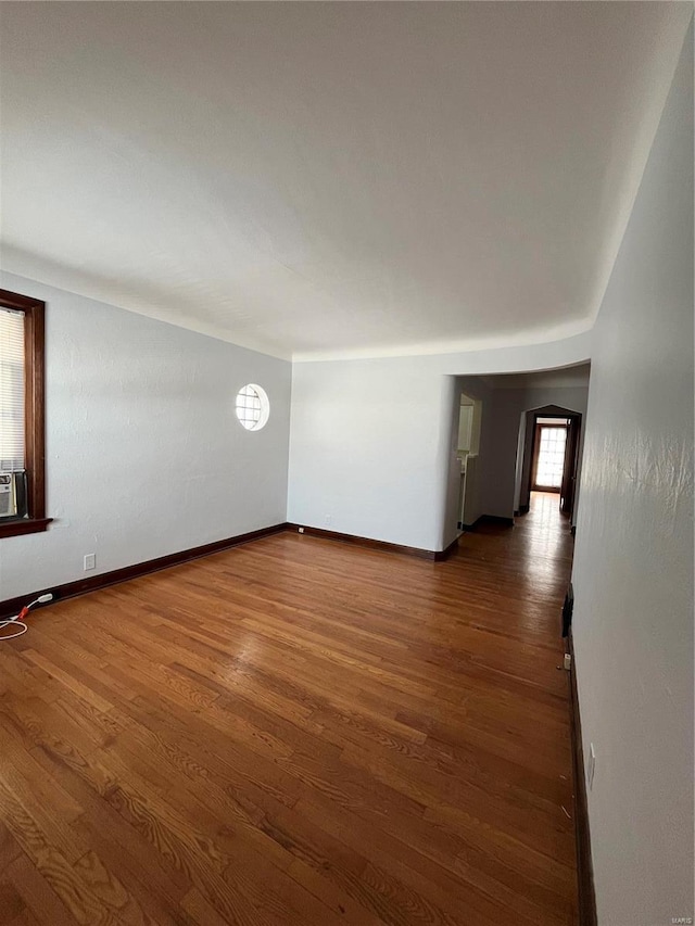 unfurnished room with dark wood-style floors and baseboards