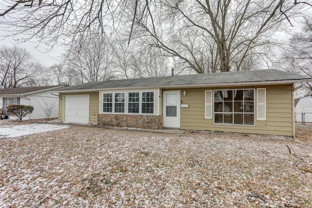 single story home with a garage, stone siding, and concrete driveway