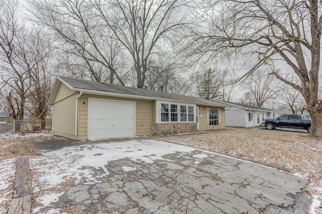 view of front facade with a garage, driveway, and fence