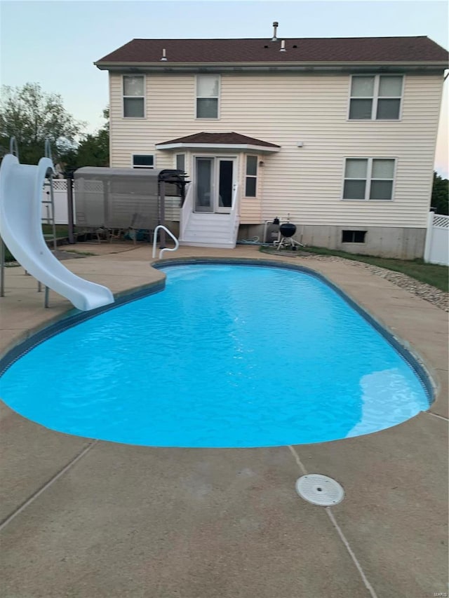 view of pool featuring a fenced in pool, a patio, a water slide, and fence