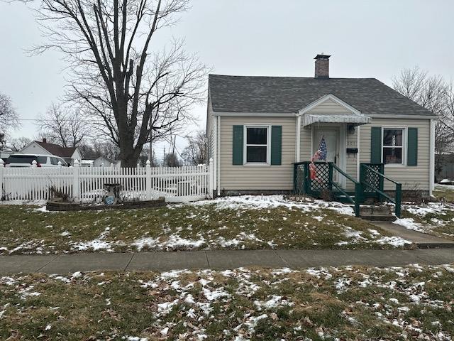 bungalow with a fenced front yard and a chimney